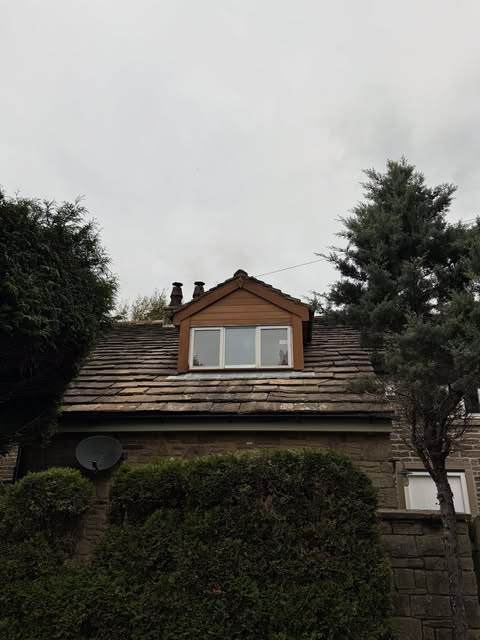 Cedar-clad dormer window set into a slate roof