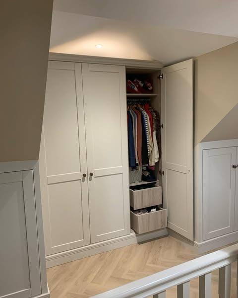 Open fitted wardrobe under the eaves with hanging rail and drawers